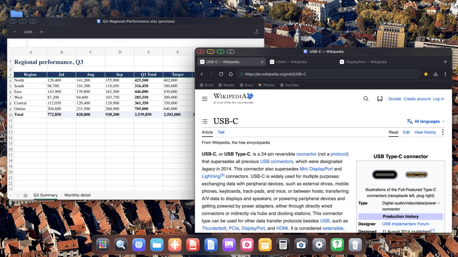 A spreadsheet open beside a live web page on an external display.