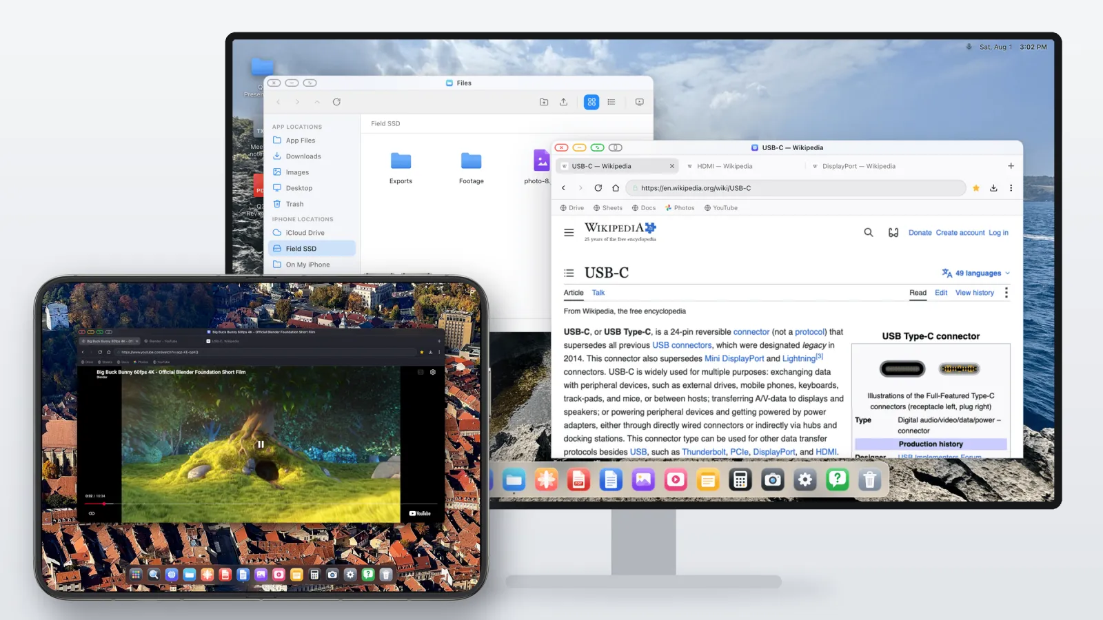 An iPhone Duo held in landscape in front of an external monitor. The monitor shows a desktop with a file manager and a browser, and the Duo shows a YouTube video in its own browser window above a dock.
