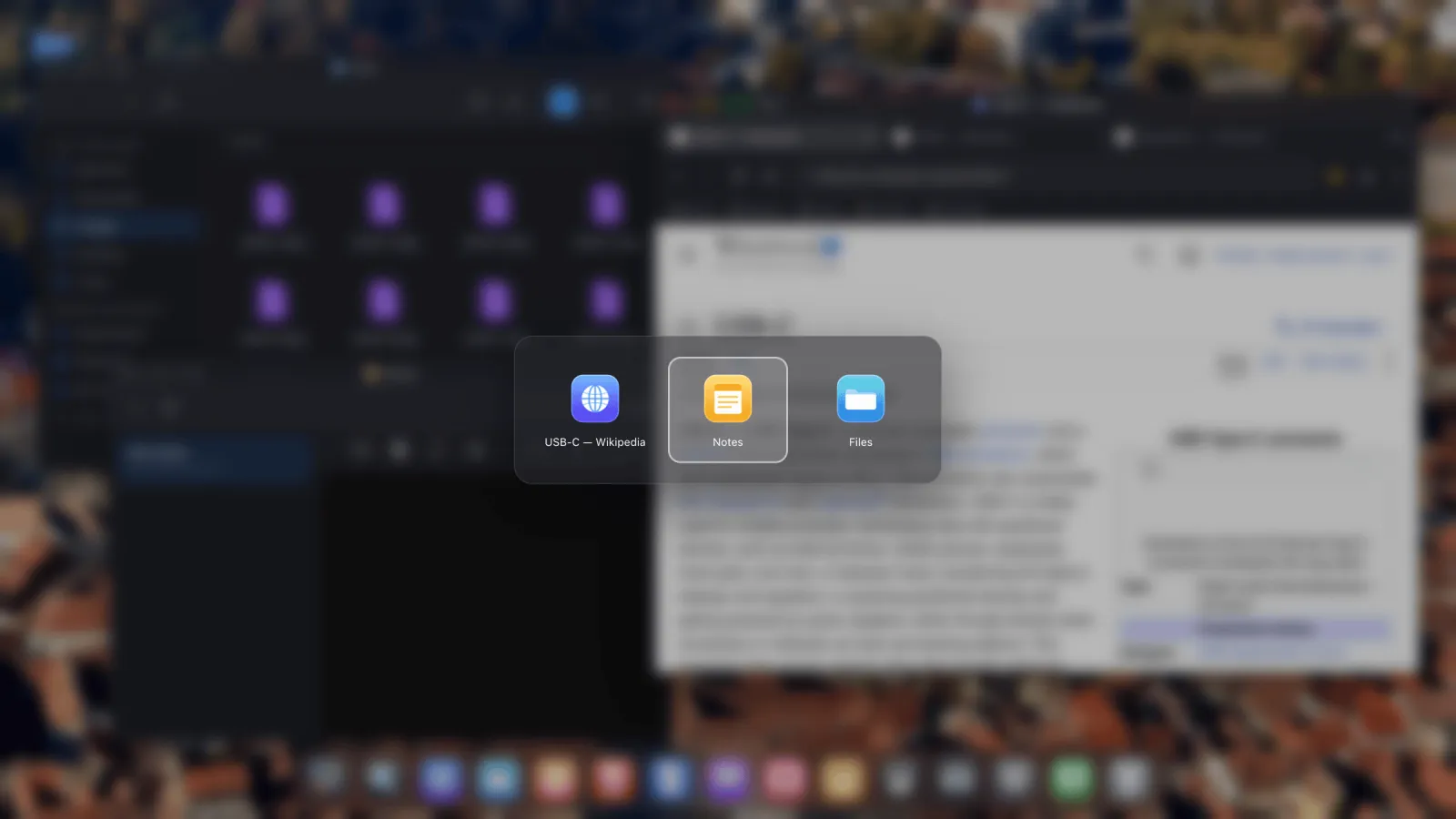 An app switcher overlay showing icons for several open windows on an external display.